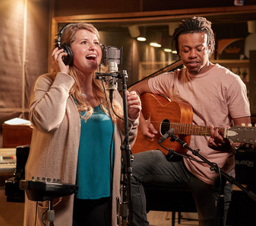 female sings while male plays guitar