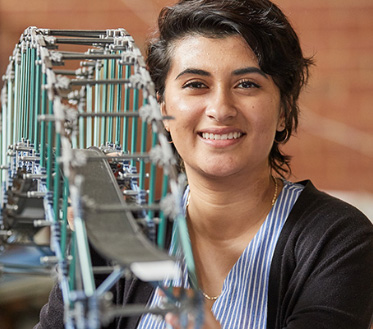 student with bridge model in foreground