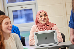 student in classroom with ipad
