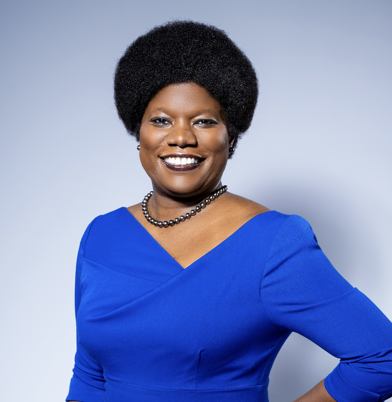 Tona Boyd, in a blue dress, smiles for the camera. 
