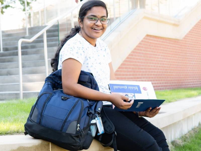 student on steps with book