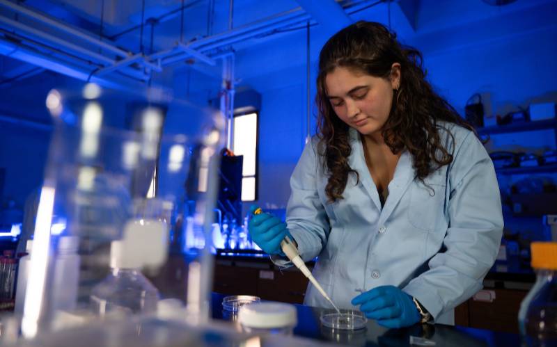 student working with pipette in lab