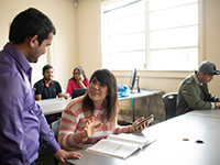 professor speaking to international student in classroom