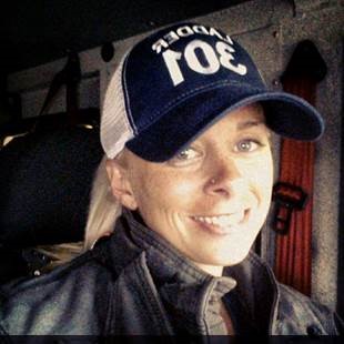 Sarah Bottle smiles with a baseball cap on