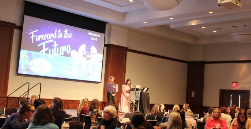 two students on stage at conference