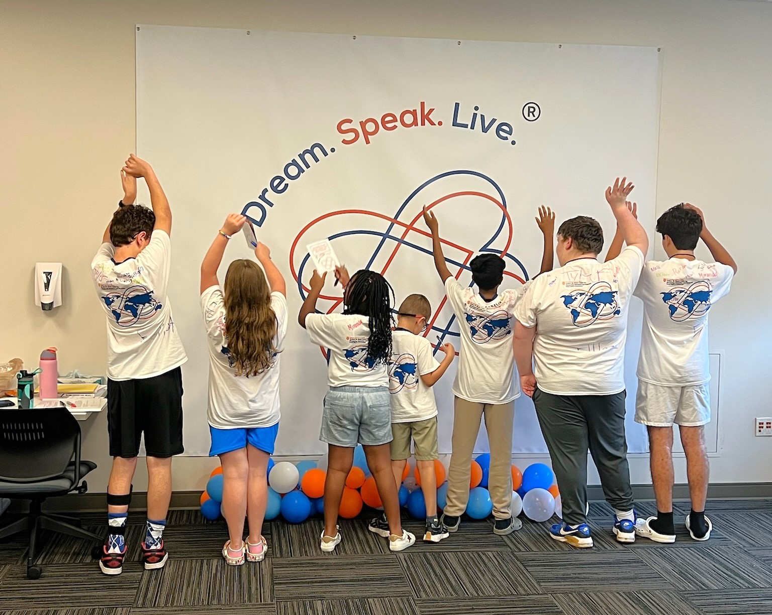 Campers standing and facing the Camp Dream, Speak, Live poster