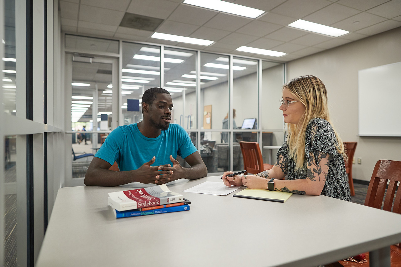 writing center employee helping student with paper