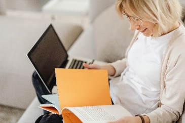 student with book and laptop