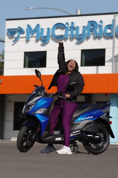 Participant cheering in front of the MyCityRides sign.