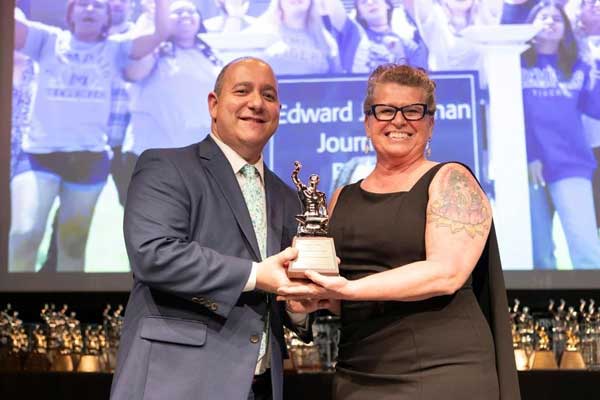 JRSM faculty member, Kim Marks Malone accepts the Silver Anvil award for the UofM