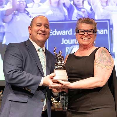 JRSM faculty member, Kim Marks Malone accepts the Silver Anvil award for the UofM