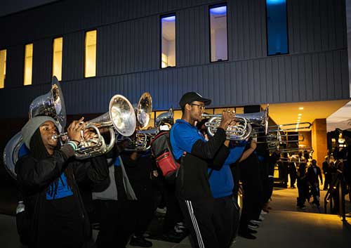 Mighty Sound of the South band members play brass instruments outside of the Scheidt Performing Arts Center