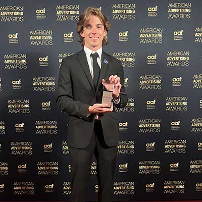 Zach Wall posing with his Silver ADDY award