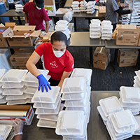 Chartwells employee packages food with several workers and food packages surrounding her