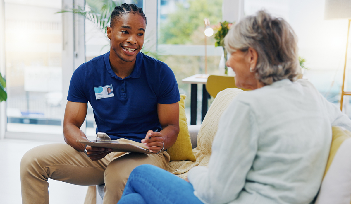 Photo of African-American man talking to an older Caucasian woman. 