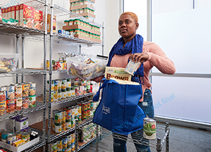 Student in pantry grabbing cans off shelf