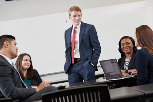 decorative - male student stands and talks to peers