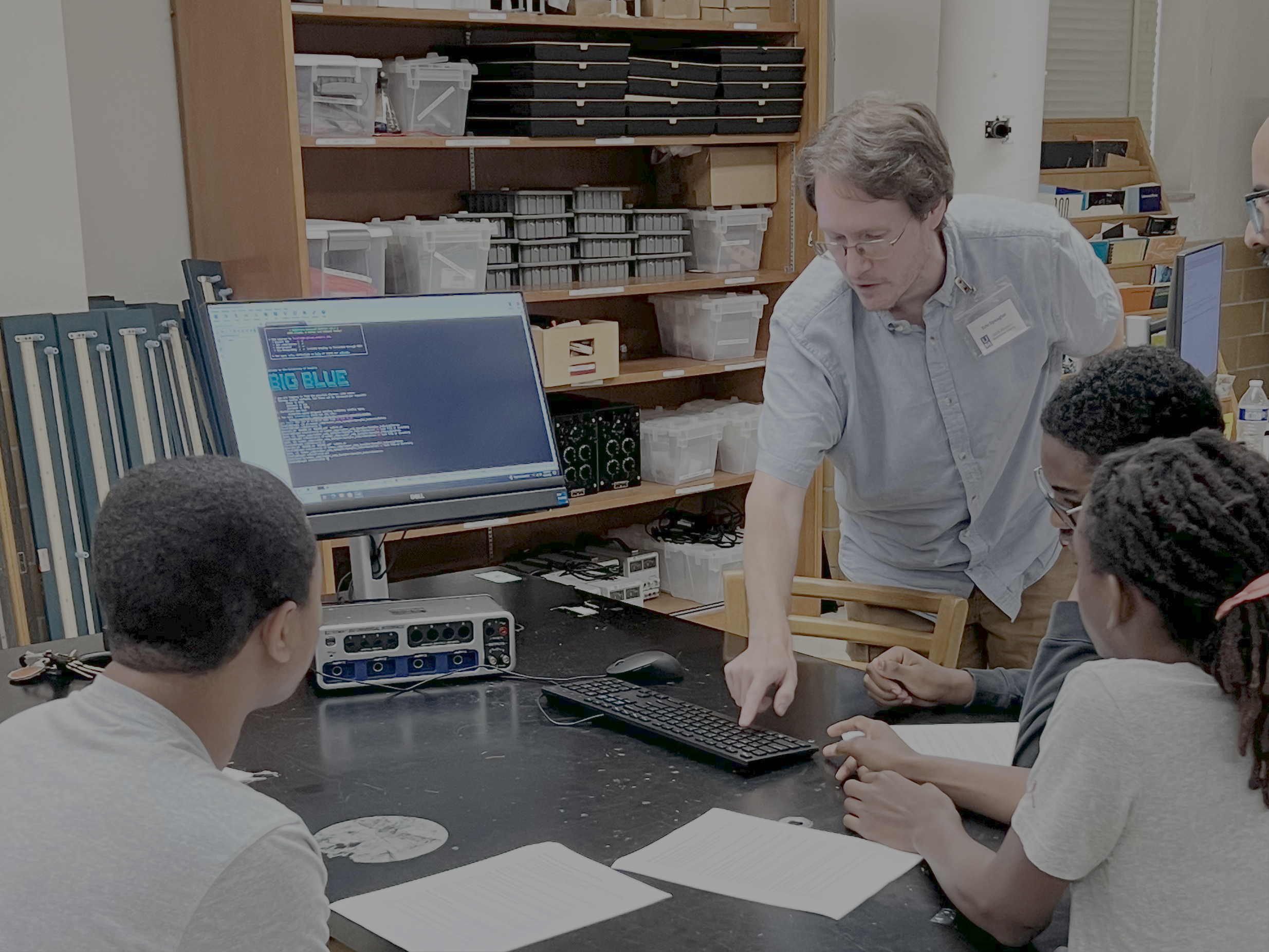 Research Computing employee helps high school kids learning coding