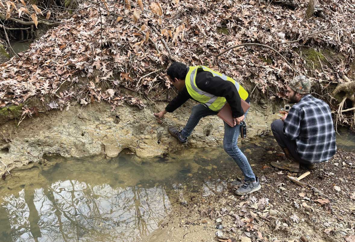 A field photo of Narayan Adhikari and Jeffery Collins investigating an outcrop on the Leapwood 7.5-minute quadrangle in western Tennessee.