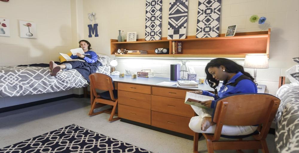 two students studying and relaxing in a Rawls Hall double bed dorm room 