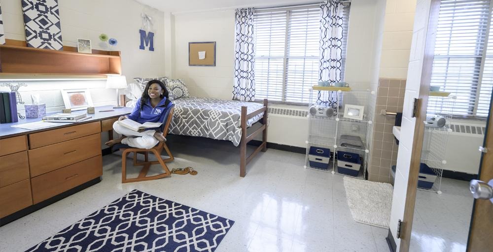 student relaxes in their Rawls Hall double bed dorm room 