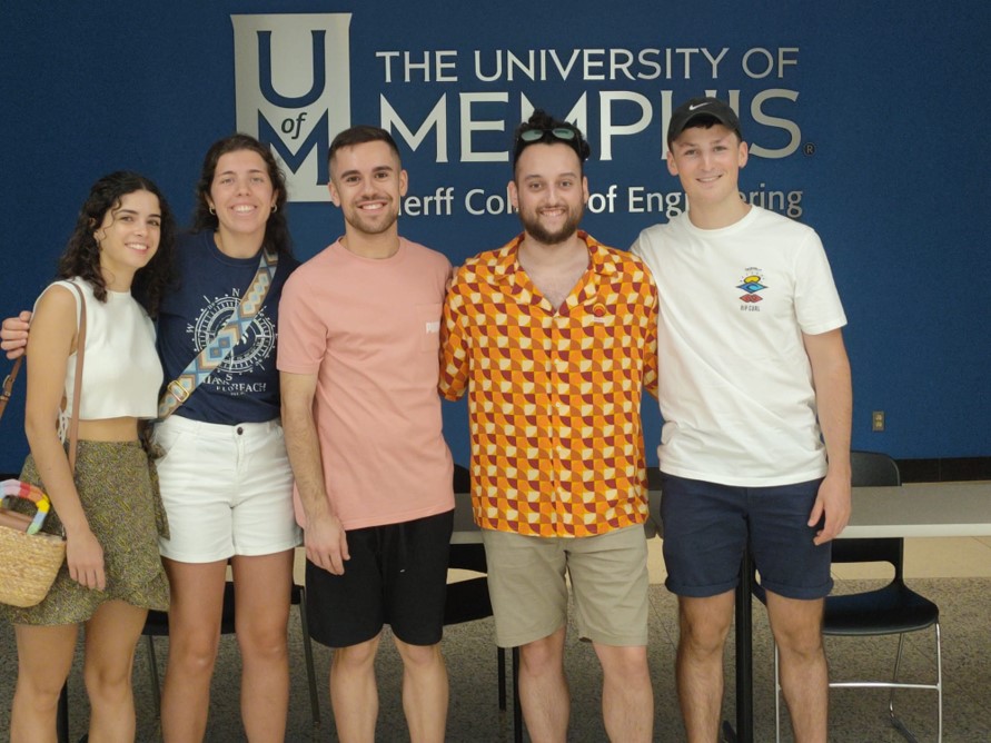 posing in front of Herff logo in Engineering Administration Building lobby
