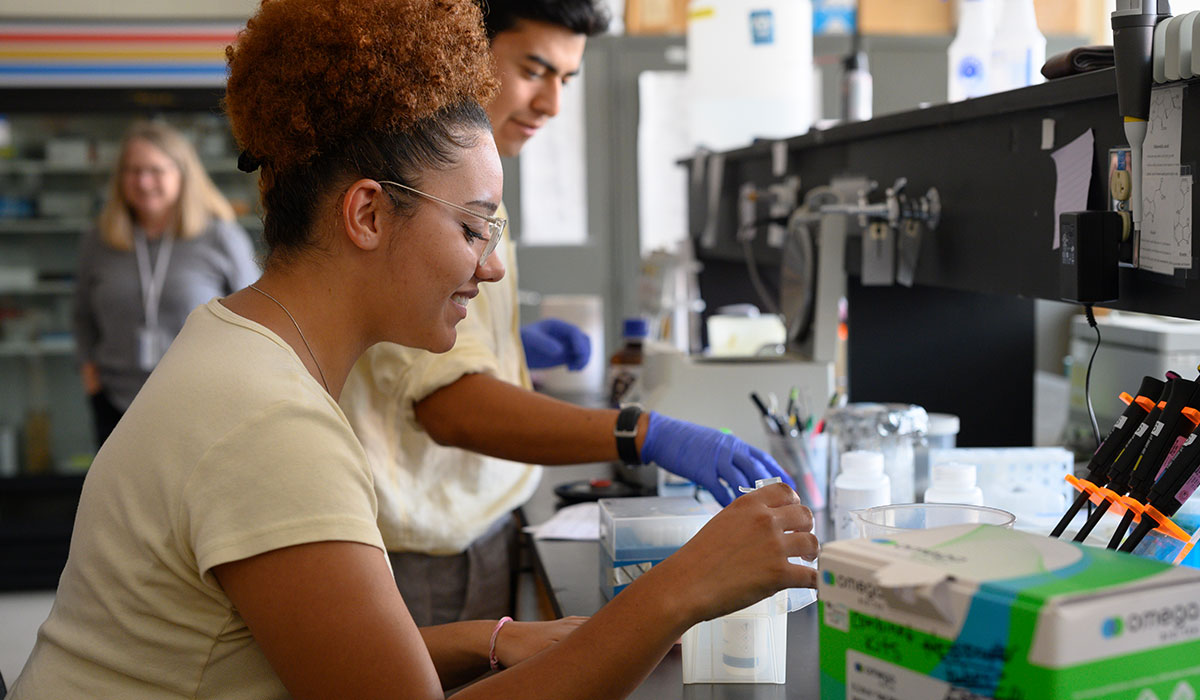 Female student at a reasearch bench with lab materials around her