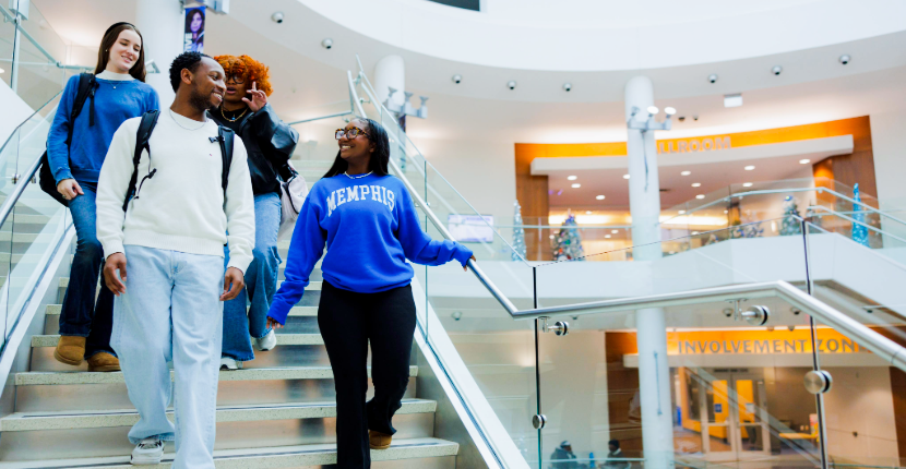 students walking down the UC atrium stairs