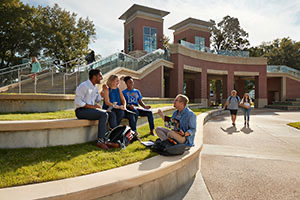 hands holding iPhone with UofM Admin on photo background