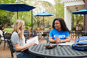 hands holding iPhone with UofM Admin on photo background
