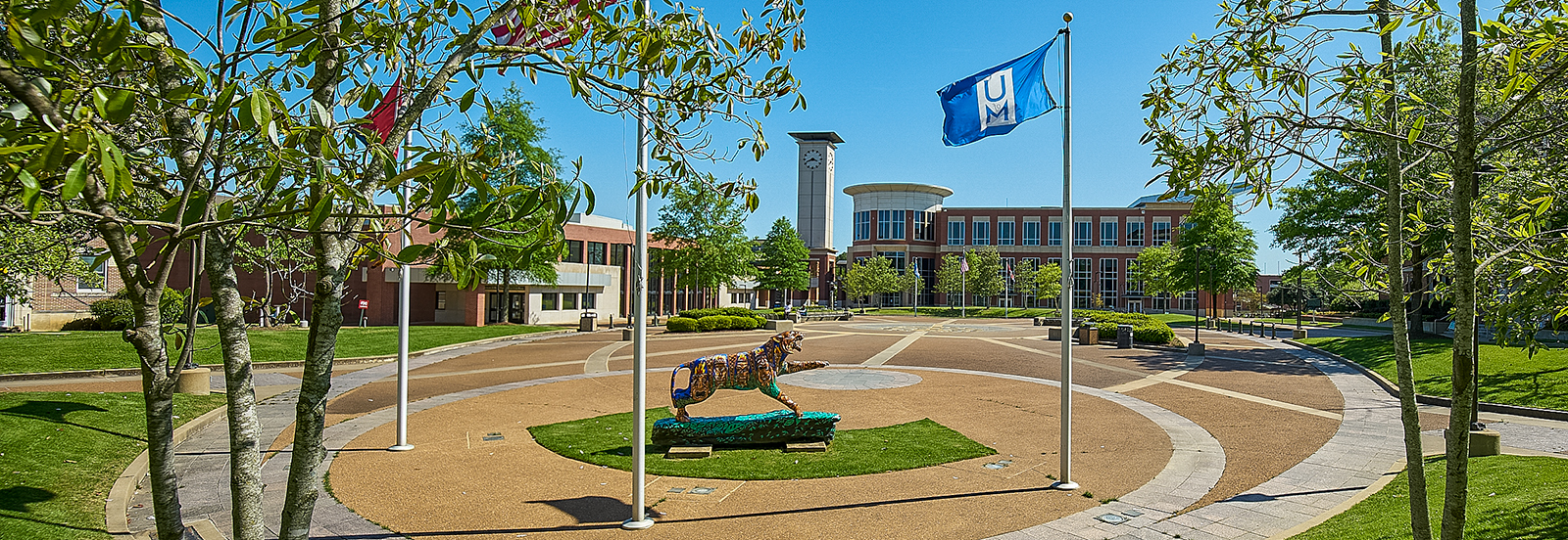 UofM Student Plaza with tiger statue, UofM flags and University Center in the background