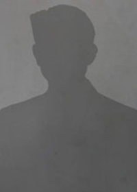 Silhouette of a person set against a plain gray background. The figure is posed upright, with minimal visible detail.