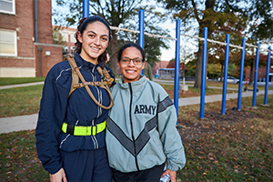 two women standing in front of pullup bars