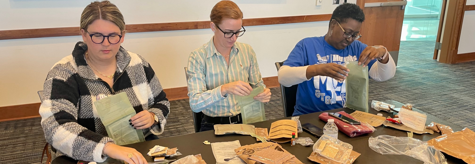 three people sitting at table during military student event