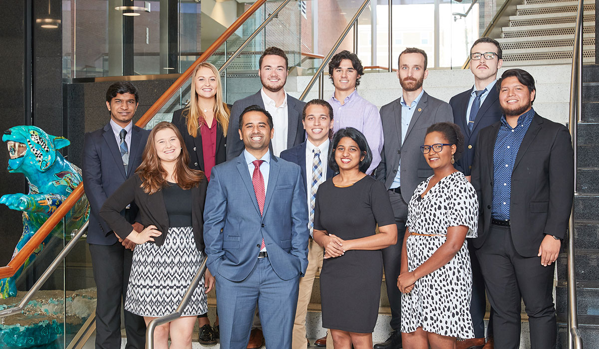 Graduate students posing for picture in business attire